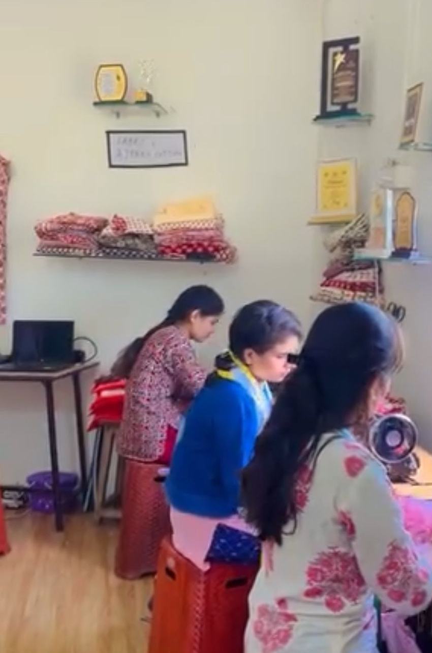 Students cutting and stitching at the machines